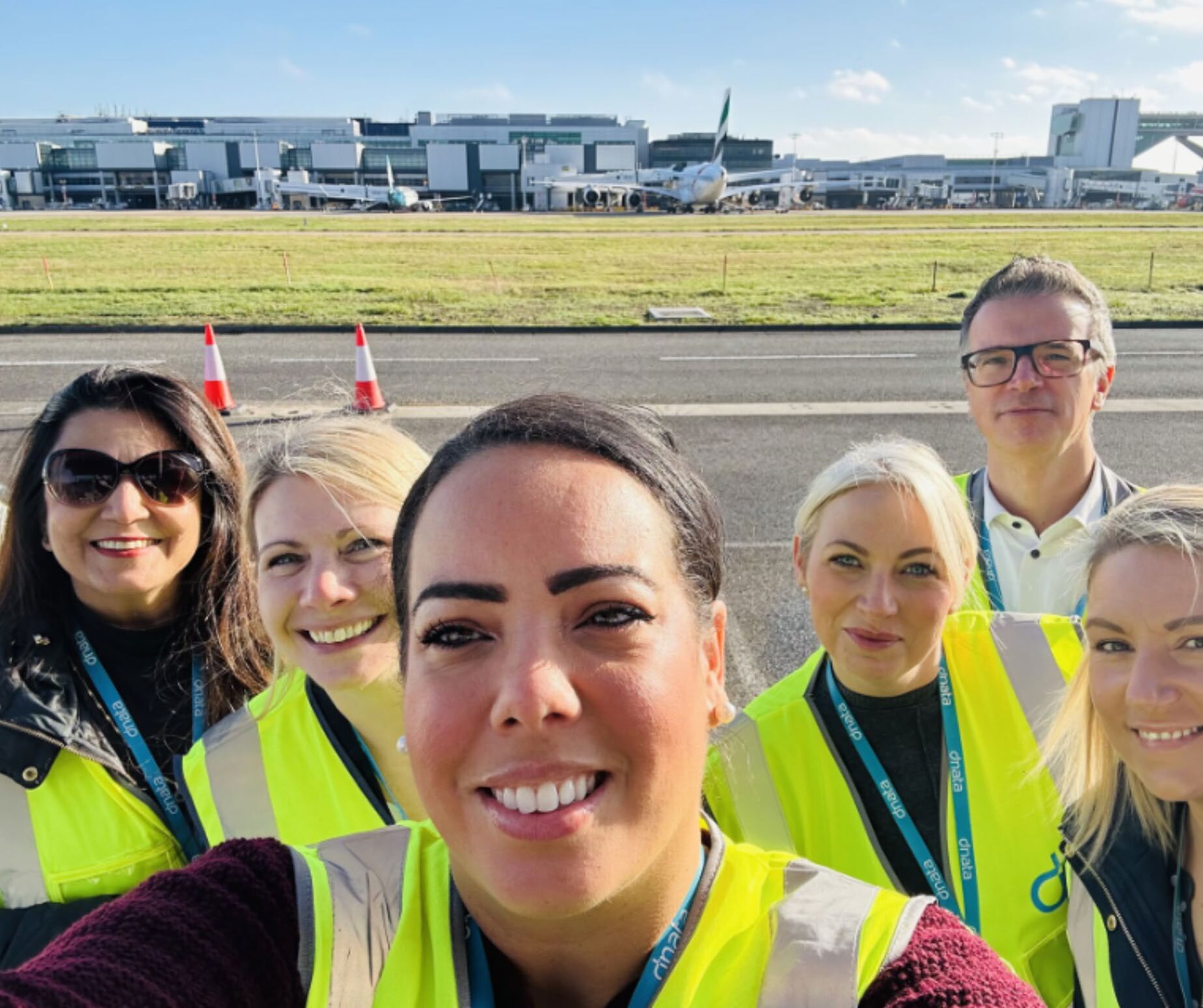 dnata UK ground-handling team in hi-vis on the airport apron — Pads on a Roll installed across six UK airports.