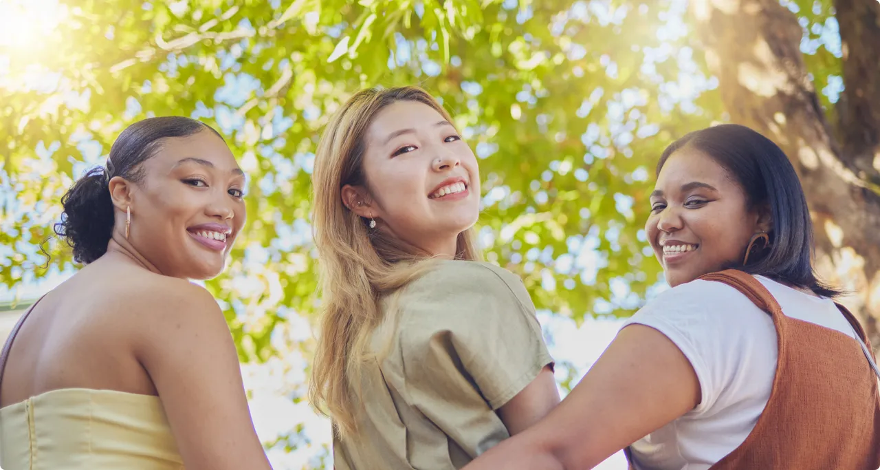 Three students smiling together outdoors